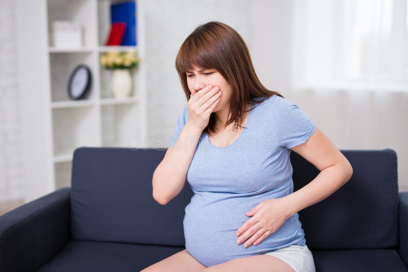 Mulher gravida nova que sofre com náusea foto de stock Mulher gravida nova que sofre com náusea foto de stock