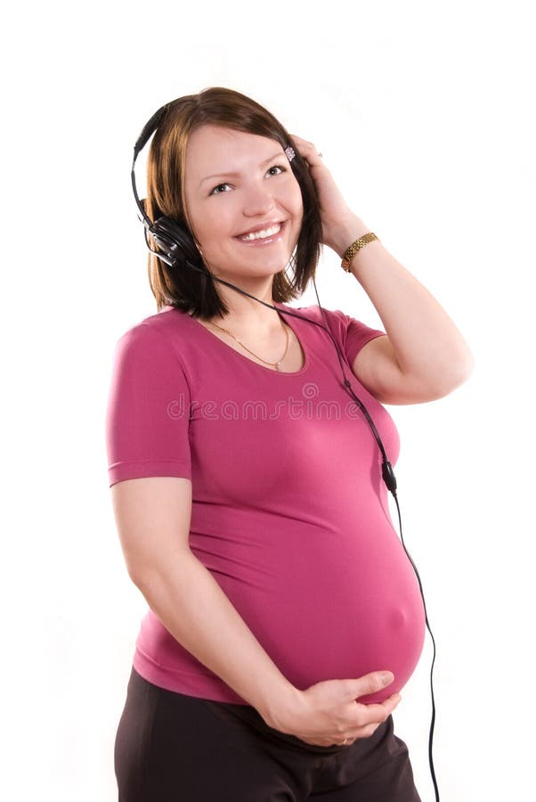 Mulher gravida que escuta a música fotografia de stock Mulher gravida que escuta a música fotografia de stock