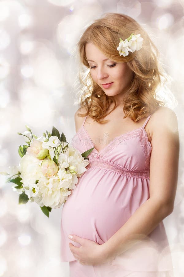 Mulher gravida que olha a barriga foto de stock royalty free Mulher gravida que olha a barriga foto de stock royalty free