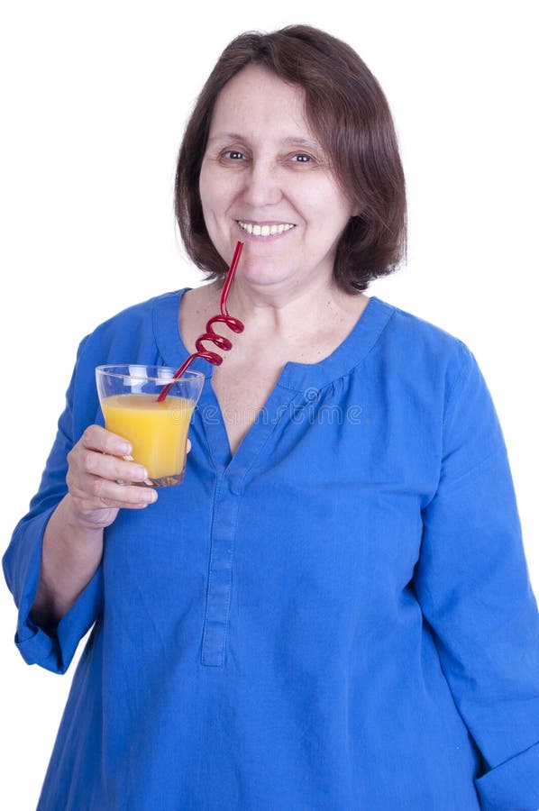A mulher idosa bebe o sumo de laranja fotografia de stock royalty free