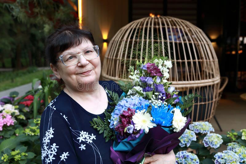 Mulher idosa com buquê de flores imagem de stock