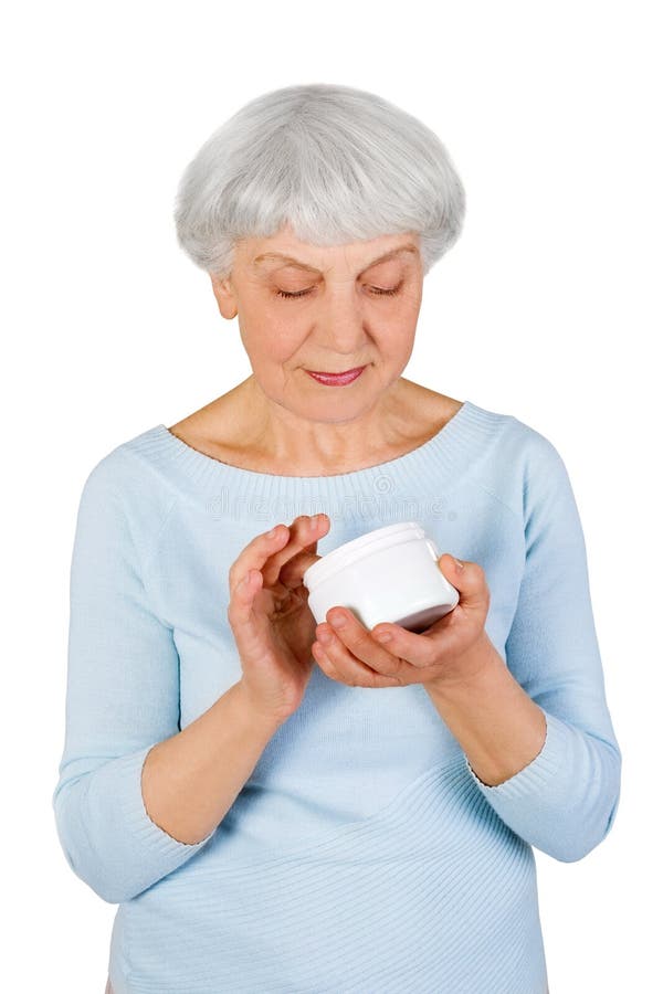 Mulher idosa encantador que aplica o creme cosmético em sua cara para cuidados com a pele faciais em um fundo branco imagem de stock royalty free Mulher idosa encantador que aplica o creme cosmético em sua cara para cuidados com a pele faciais em um fundo branco imagem de stock royalty free