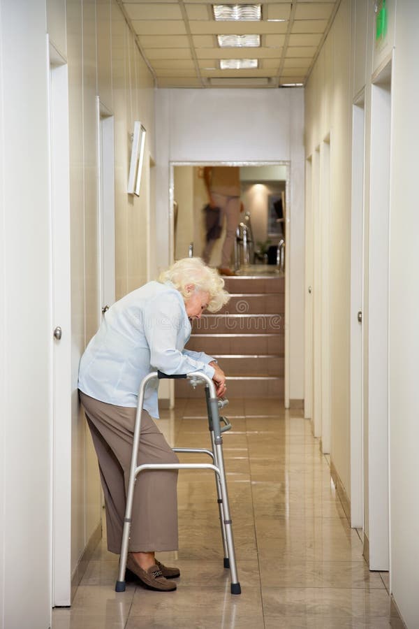 Mulher idosa que está no corredor