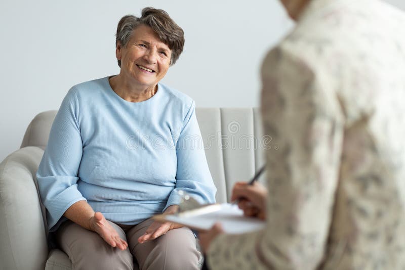 Mulher idosa que fala a um conselheiro financeiro sobre um empréstimo imagem de stock Mulher idosa que fala a um conselheiro financeiro sobre um empréstimo imagem de stock