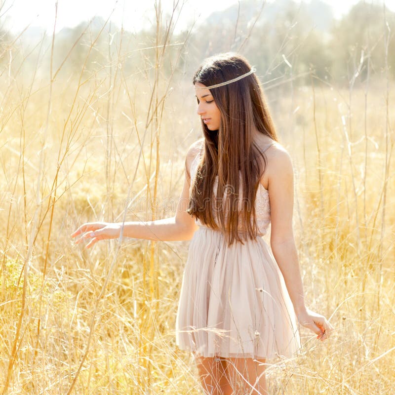 Mulher indiana asiática que anda no campo secado dourado fotografia de stock Mulher indiana asiática que anda no campo secado dourado fotografia de stock
