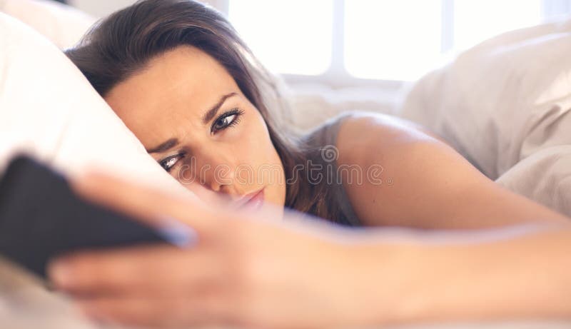 Mulher infeliz com uma mensagem de texto imagens de stock Mulher infeliz com uma mensagem de texto imagens de stock