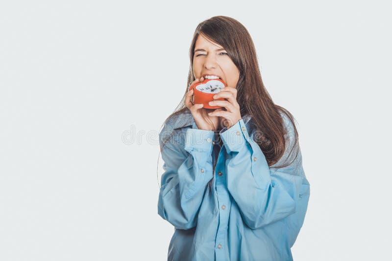 Mulher irritada na camisa grande que guarda o despertador fotos de stock Mulher irritada na camisa grande que guarda o despertador fotos de stock