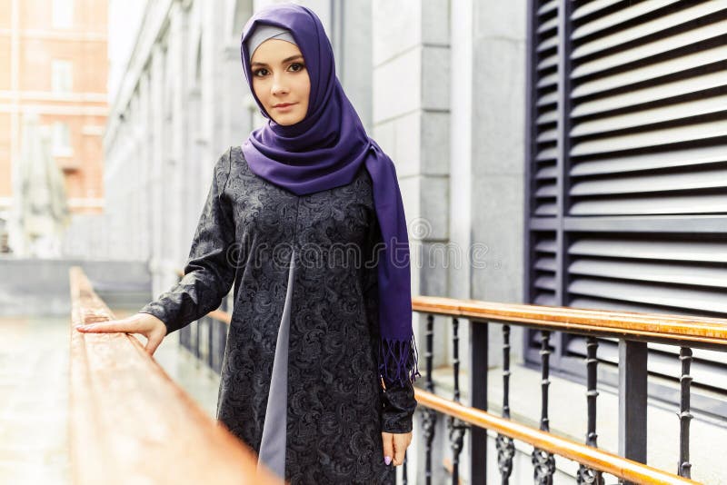 Mulher islâmica bonita na roupa oriental tradicional que está em uma rua da cidade foto de stock royalty free Mulher islâmica bonita na roupa oriental tradicional que está em uma rua da cidade foto de stock royalty free