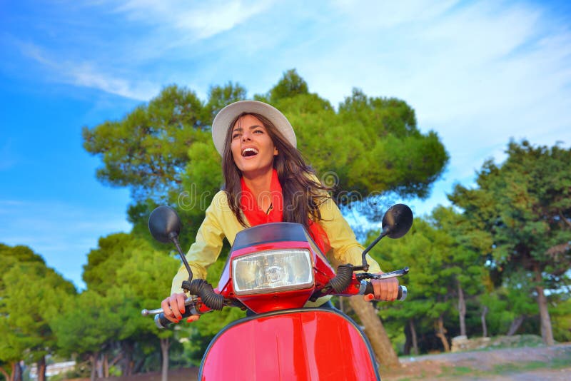 Mulher italiana bonita nova que senta-se em um 'trotinette' italiano em montes de Itália foto de stock Mulher italiana bonita nova que senta-se em um 'trotinette' italiano em montes de Itália foto de stock