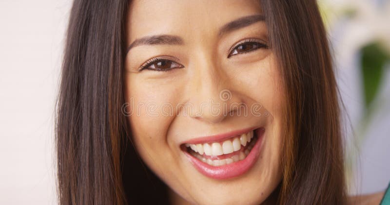 Mulher japonesa que sorri e que olha a câmera imagem de stock Mulher japonesa que sorri e que olha a câmera imagem de stock
