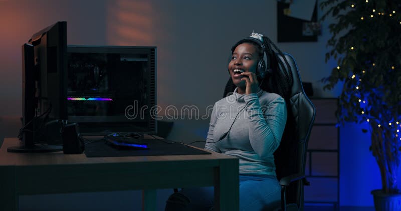 Mulher joga computador profissionalmente com a equipe com a qual ela fala através da equipe do fone ganha em virtual online