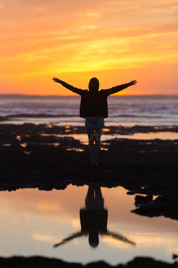 Mulher livre que aprecia a liberdade na praia no por do sol imagem de stock Mulher livre que aprecia a liberdade na praia no por do sol imagem de stock