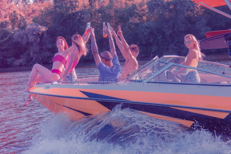 Mulher loura que dirige um barco com seus amigos foto de stock Mulher loura que dirige um barco com seus amigos foto de stock