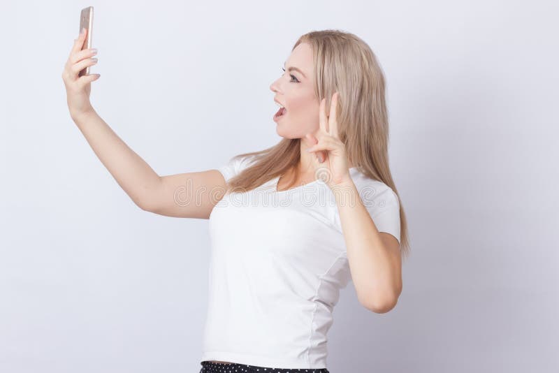 Mulher loura que faz o selfie no telefone celular imagens de stock Mulher loura que faz o selfie no telefone celular imagens de stock