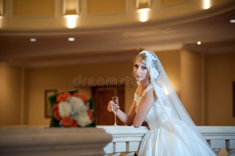 Mulher luxuoso bonita nova no vestido de casamento que levanta no interior luxuoso Noiva com o vestido de casamento enorme no sol imagem de stock Mulher luxuoso bonita nova no vestido de casamento que levanta no interior luxuoso Noiva com o vestido de casamento enorme no sol imagem de stock