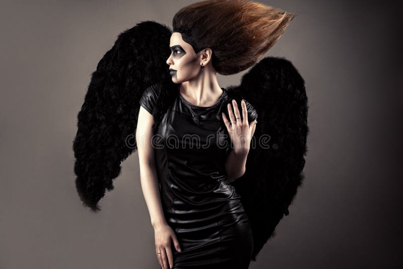 Mulher luxuoso com cabelo luxúria e composição escura com asas pretas imagem de stock royalty free Mulher luxuoso com cabelo luxúria e composição escura com asas pretas imagem de stock royalty free
