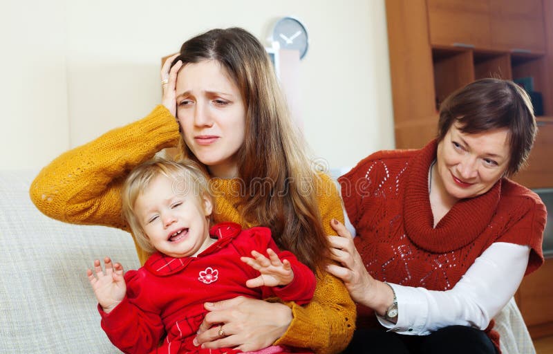 Mulher madura que consola a filha adulta com bebê fotografia de stock royalty free Mulher madura que consola a filha adulta com bebê fotografia de stock royalty free