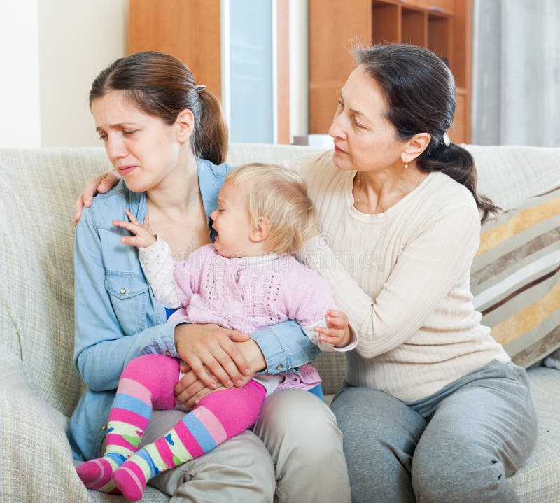 Mulher madura que consola a filha adulta com criança imagem de stock Mulher madura que consola a filha adulta com criança imagem de stock