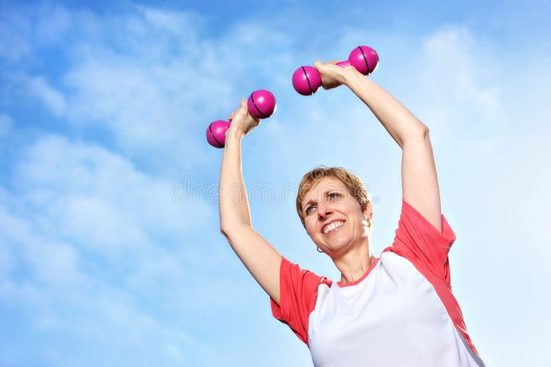 Mulher madura que exercita ao ar livre com dumbbells imagens de stock royalty free