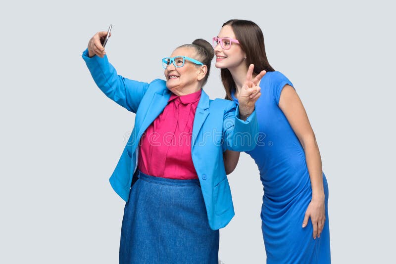 Mulher mais idosa com a neta que faz o selfie e o sorriso toothy foto de stock royalty free Mulher mais idosa com a neta que faz o selfie e o sorriso toothy foto de stock royalty free