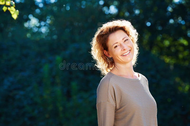 Mulher mais idosa feliz que está no parque tranquilo fotos de stock Mulher mais idosa feliz que está no parque tranquilo fotos de stock