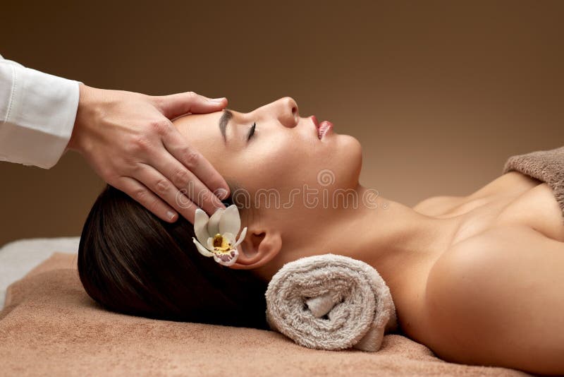 Mulher massageando cara e cabeça no spa fotografia de stock royalty free Mulher massageando cara e cabeça no spa fotografia de stock royalty free
