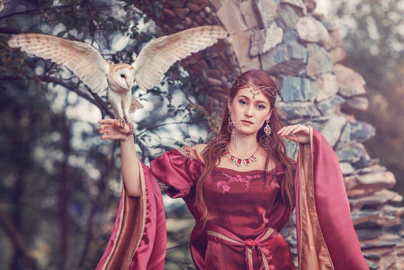 Beautiful medieval woman, sorceress, with a flying owl on her hand. Amazing scene near ancient stone arc. Beautiful medieval woman, sorceress, with a flying owl on her hand. Amazing scene near ancient stone arc.