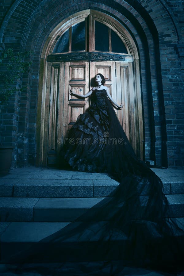 Mulher misteriosa no vestido preto perto da igreja fotos de stock royalty free Mulher misteriosa no vestido preto perto da igreja fotos de stock royalty free