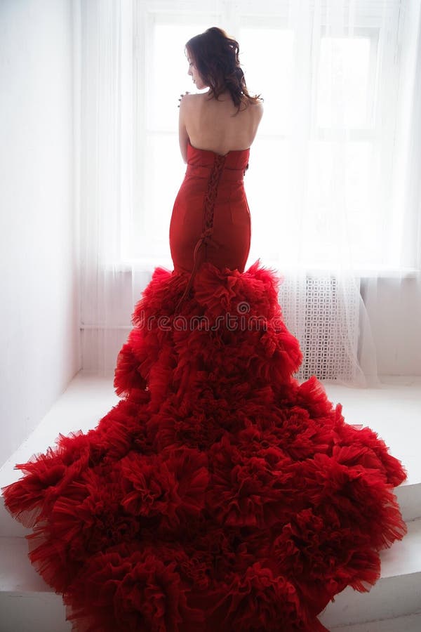 Mulher modelo moreno da beleza em nivelar o vestido vermelho Arrelia bonita imagem de stock royalty free Mulher modelo moreno da beleza em nivelar o vestido vermelho Arrelia bonita imagem de stock royalty free