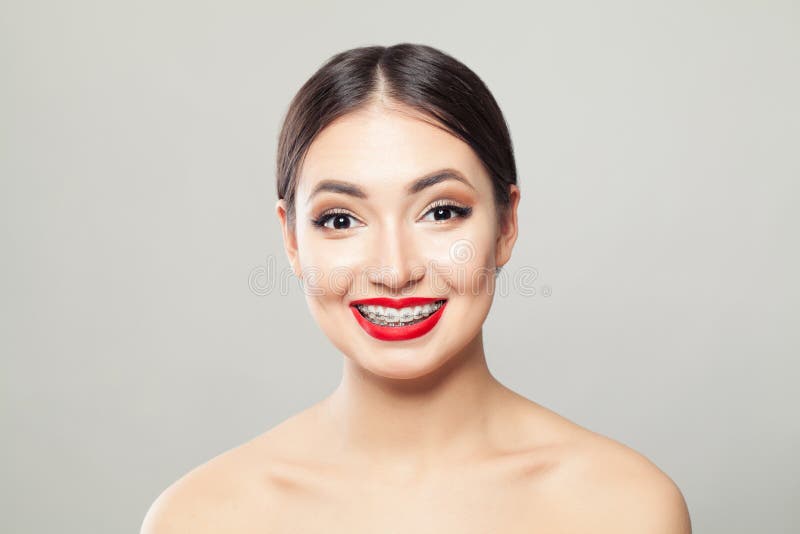 Mulher moreno atrativa nas cintas que sorri no fundo branco imagens de stock royalty free Mulher moreno atrativa nas cintas que sorri no fundo branco imagens de stock royalty free