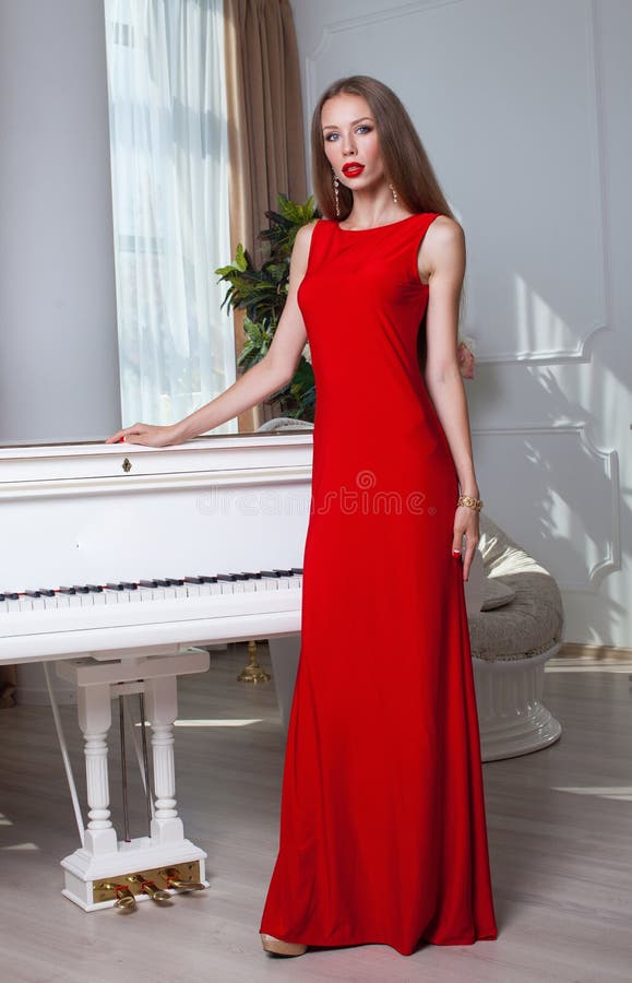 Mulher moreno bonita em um vestido vermelho Tiro do estúdio Cabelo longo Bordos vermelhos fotografia de stock royalty free Mulher moreno bonita em um vestido vermelho Tiro do estúdio Cabelo longo Bordos vermelhos fotografia de stock royalty free