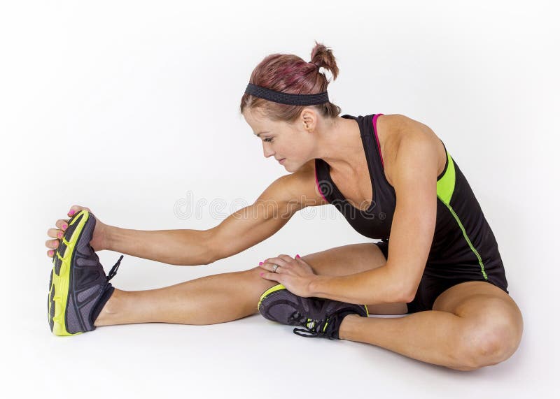 Mulher muscular forte que estica antes do exercício no fundo branco foto de stock royalty free