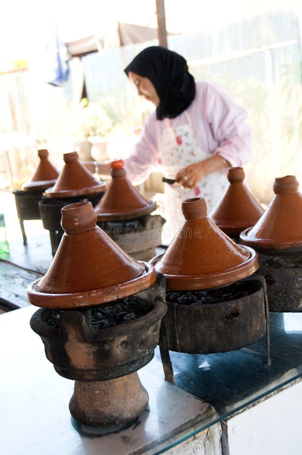 Mulher muçulmana que cozinha o alimento no tagine Marrocos foto de stock Mulher muçulmana que cozinha o alimento no tagine Marrocos foto de stock