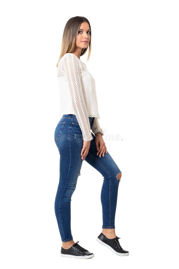 Mulher na moda nova à moda nas calças de brim e na camisa branca trançada que olham a câmera imagens de stock Mulher na moda nova à moda nas calças de brim e na camisa branca trançada que olham a câmera imagens de stock