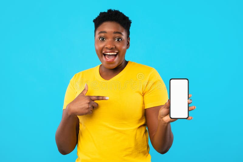 Mulher negra excitada apontando para a tela do telefone sobre fundo azul