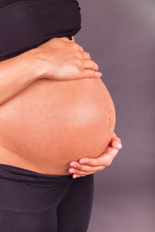 Mulher negra grávida dos jovens que toca em sua barriga fotografia de stock Mulher negra grávida dos jovens que toca em sua barriga fotografia de stock