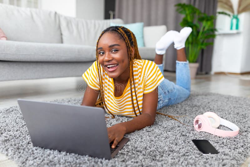 Relaxe a mulher negra no chão e o laptop para uma pausa na