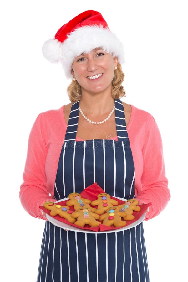 Mulher no chapéu de Santa que guardara uma placa de homens de pão-de-espécie foto de stock Mulher no chapéu de Santa que guardara uma placa de homens de pão-de-espécie foto de stock