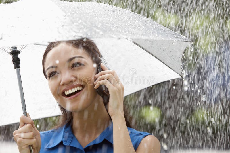 Mulher no telefone na chuva fotos de stock Mulher no telefone na chuva fotos de stock