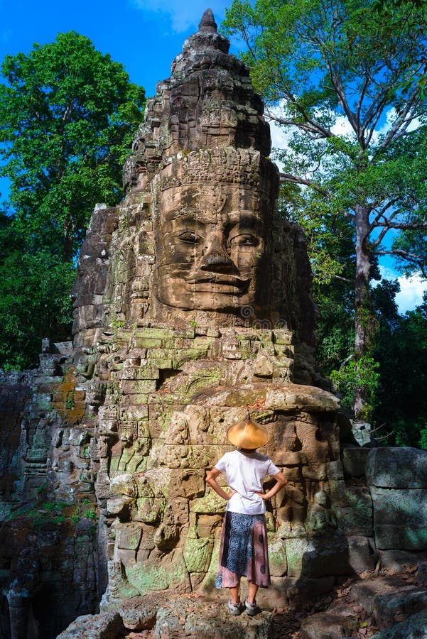 Mulher no templo de Bayon que olha as caras de pedra, Angkor Thom, c?u azul claro da luz da manh? Conceito da medita??o do budism fotografia de stock royalty free Mulher no templo de Bayon que olha as caras de pedra, Angkor Thom, c?u azul claro da luz da manh? Conceito da medita??o do budism fotografia de stock royalty free