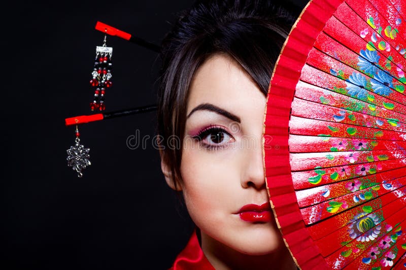 Mulher no traje asiático com o ventilador asiático vermelho