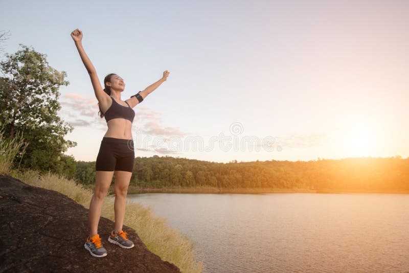 A mulher nova da aptidão consegue a caminhada no pico com por do sol da opinião do lago fotos de stock A mulher nova da aptidão consegue a caminhada no pico com por do sol da opinião do lago fotos de stock