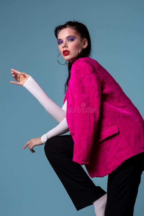 Mulher nova de surpresa do brunett no revestimento cor-de-rosa na moda que está em um pé foto de stock Mulher nova de surpresa do brunett no revestimento cor-de-rosa na moda que está em um pé foto de stock