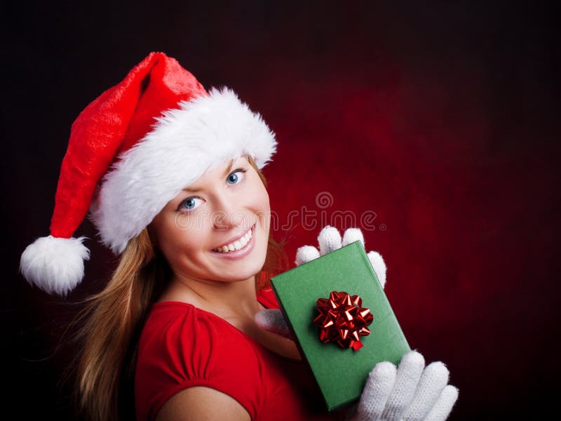 Mulher nova do Natal que prende a obscuridade excedente atual imagens de stock royalty free Mulher nova do Natal que prende a obscuridade excedente atual imagens de stock royalty free