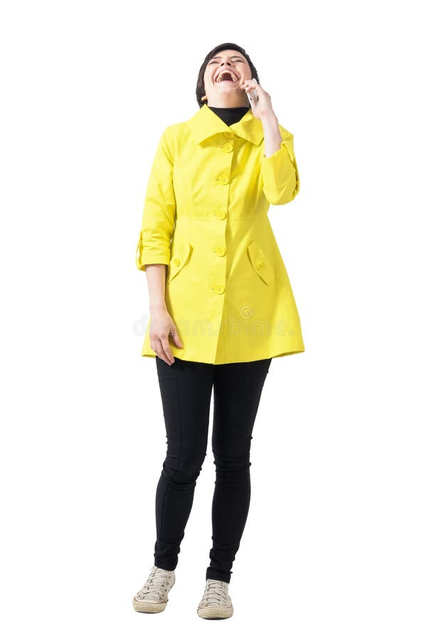 Mulher nova feliz do cabelo curto no revestimento amarelo que ri alto no telefone celular fotos de stock Mulher nova feliz do cabelo curto no revestimento amarelo que ri alto no telefone celular fotos de stock