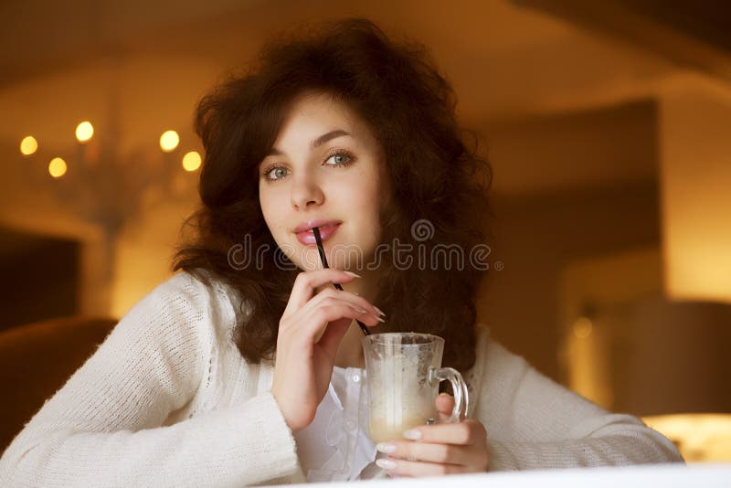 Jovem a desfrutar de um café latte num café foto de stock royalty free