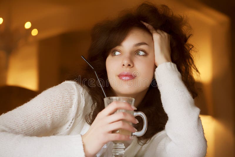 Jovem a desfrutar de um café latte num café fotos de stock royalty free