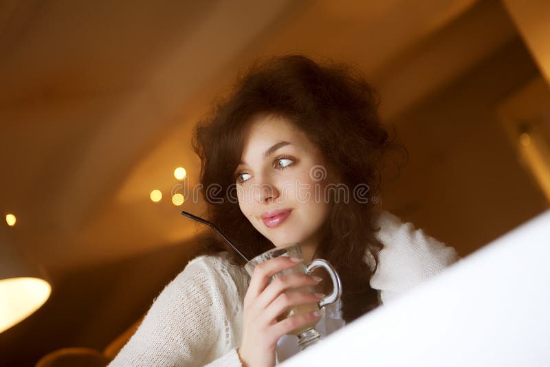 Jovem a desfrutar de um café latte num café fotografia de stock
