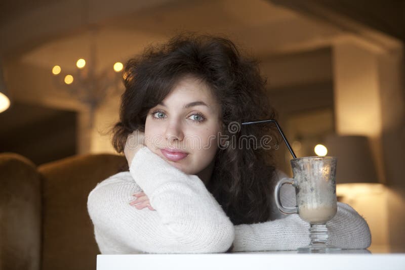 Jovem a desfrutar de um café latte num café imagem de stock