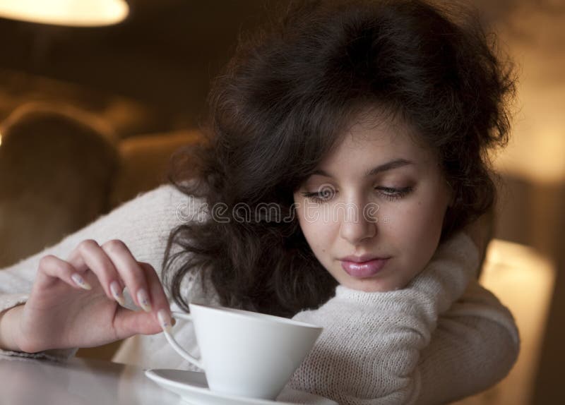 Jovem a desfrutar de um café latte num café imagens de stock